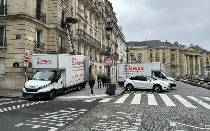 Deux camions DEMEX Déménagements dans une rue de Paris