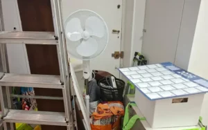 Débarras DEMEX : pièce encombrée avant intervention (escabeau, ventilateur, cartons)