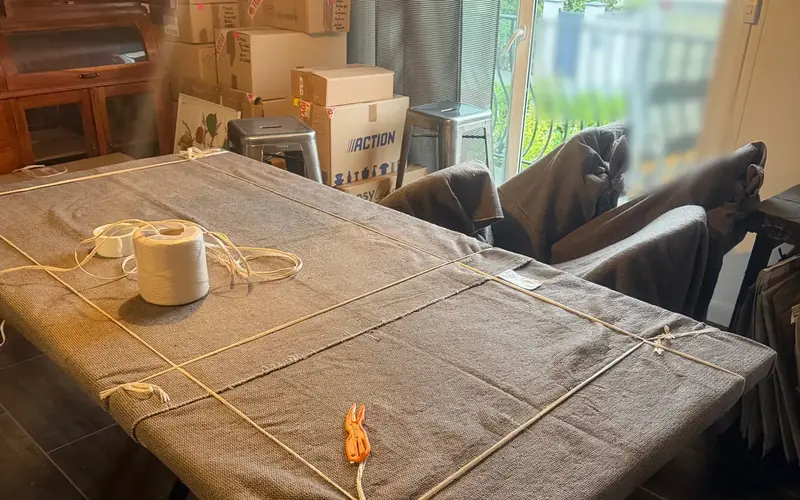 Table protégée par une couverture de déménagement et de la ficelle