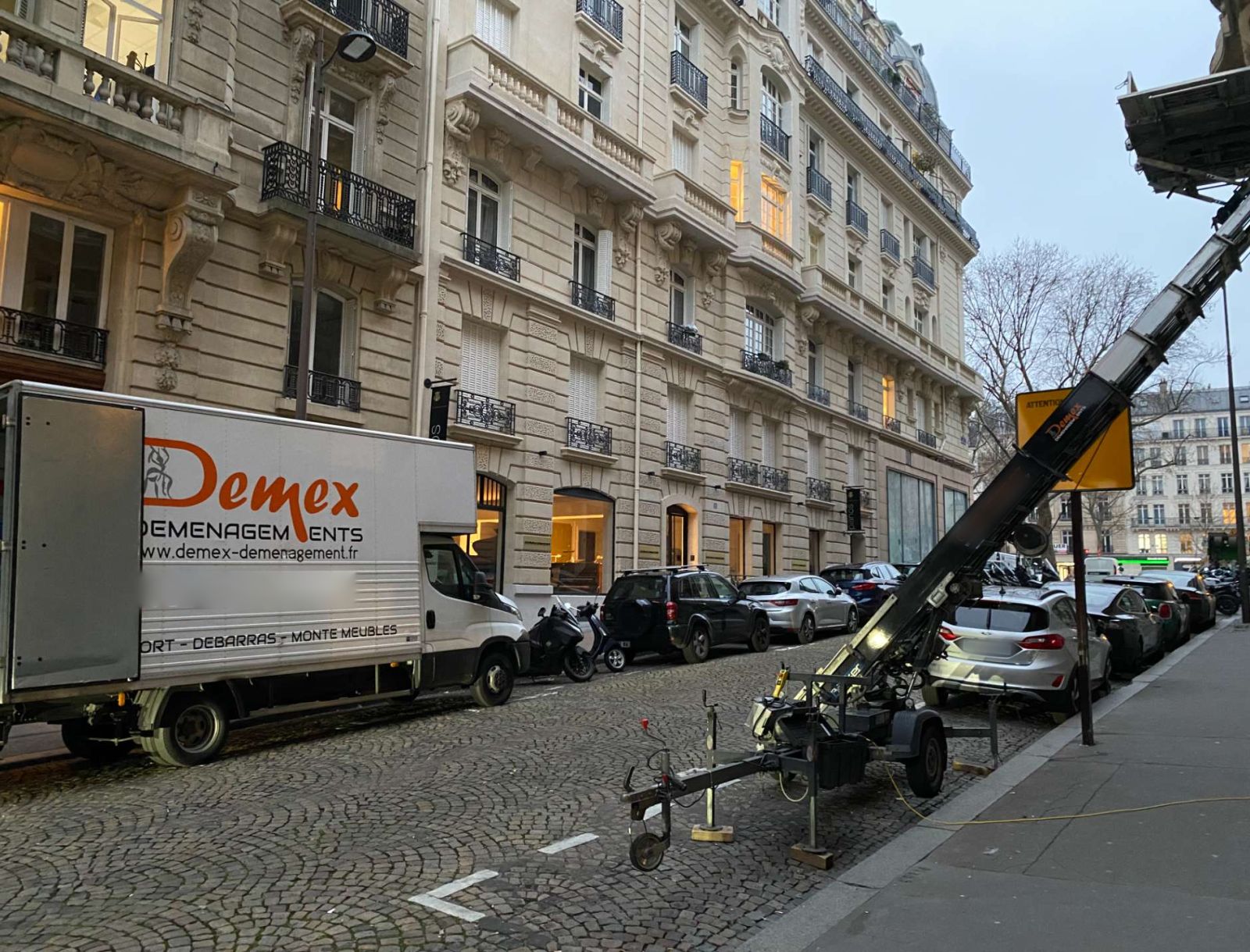 Camion DEMEX et monte-meubles installé dans une rue