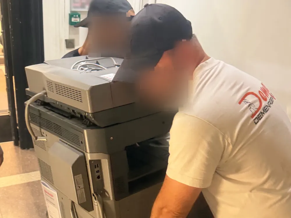 Déménageurs DEMEX manutentionnant un photocopieur professionnel