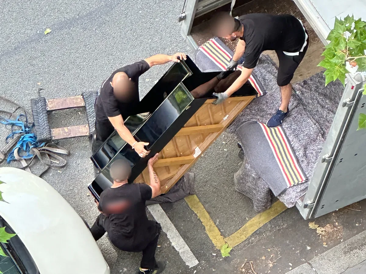 Chargement d’un piano dans le camion par l’équipe DEMEX